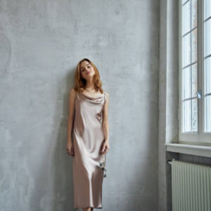 Beautiful sexy woman in a light beige silk dress. noise, out of focus
